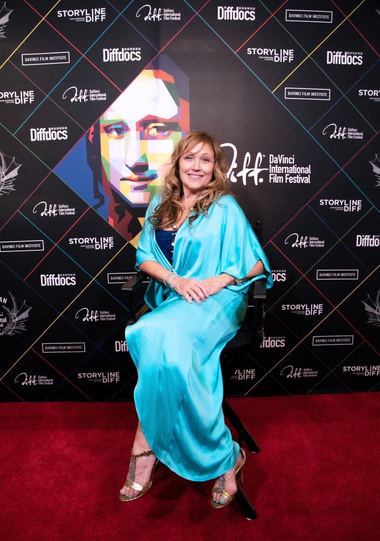 A photo of Tamara mark smiling on the red carpet.