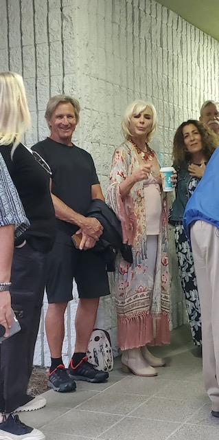 A group of individuals standing by a wall.
