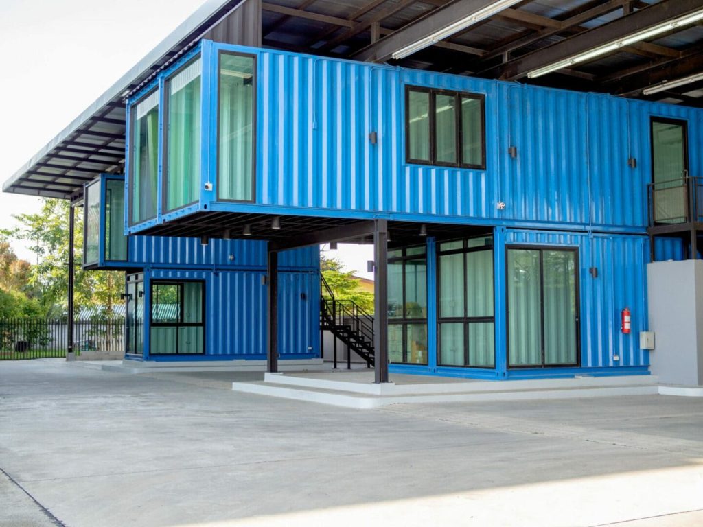 A photo of a modern blue building, made from shipping containers.