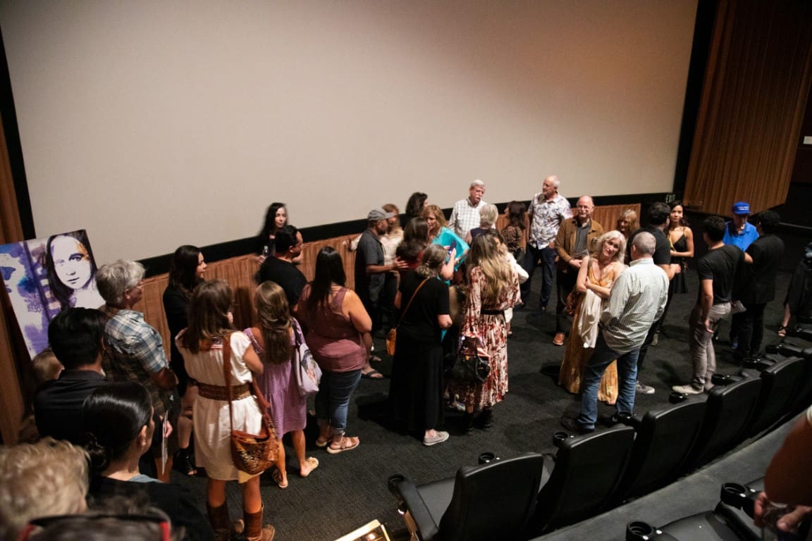 A photo of a group of individuals in front of a screen.